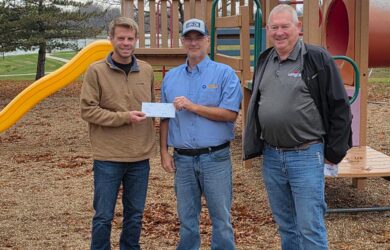 A photo of MFA Oil plant manager Kelly Van Dusen (center) and District Manager Tony Johnson (right) present a check to Parks Work in Marceline, Mo., to help purchase new playground equipment.