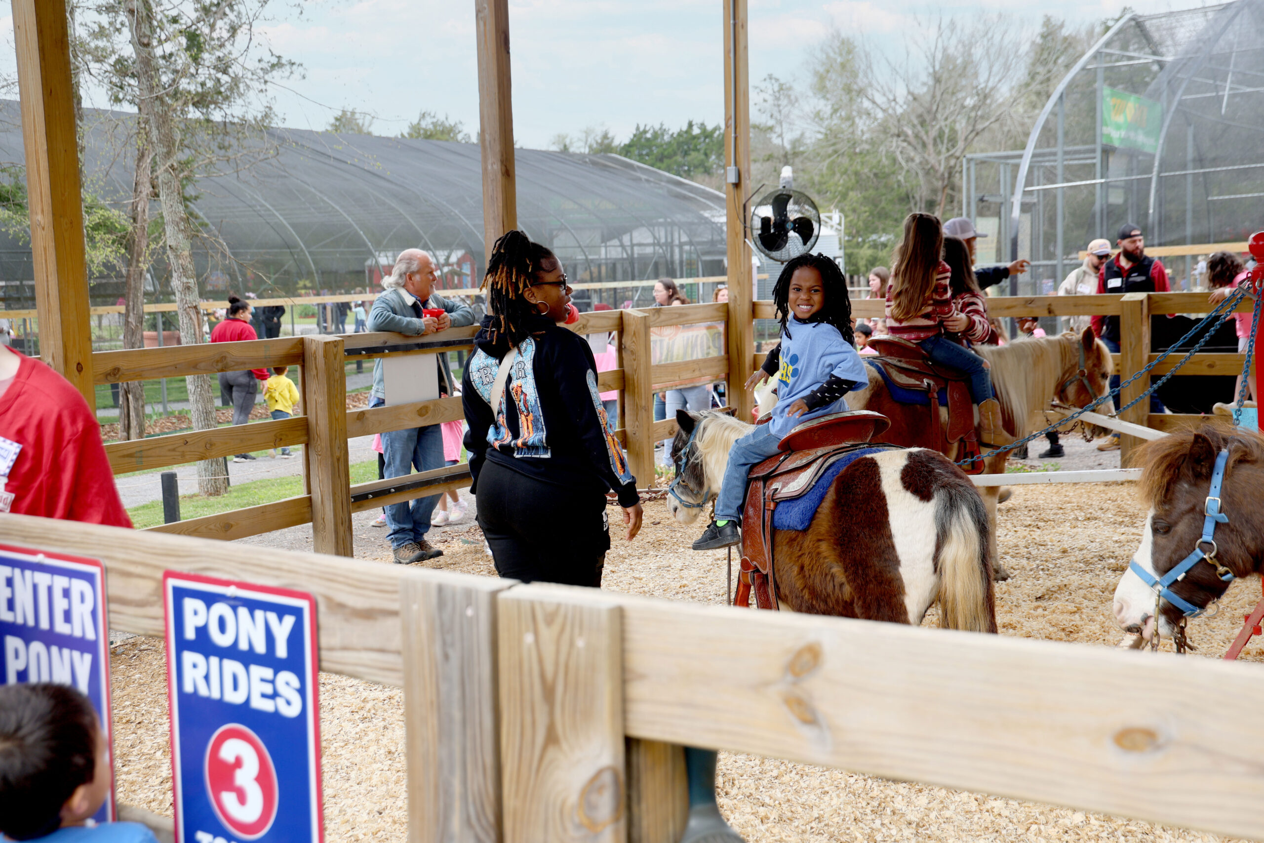 Ariana Leonard walks alongside her son Ace as he enjoys a pony ride.