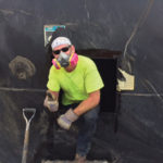 Keller Colley, senior EH&S compliance administrator, cleans out an underground storage fuel tank for disposal. Discarded tanks are frequently sold to scrap yards.