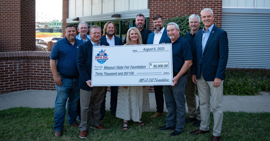 Ten people stand outdoors, smiling and holding a large ceremonial check for $30,000 made out to the Missouri State Fair Foundation from MFA Oil, dated August 6, 2025.