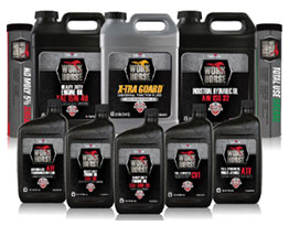 Various bottles and containers of Wolfs Head motor oil products, including multi-use and transmission fluids, are arranged in rows. The packaging features black and red labeling with the brands logo prominently displayed.